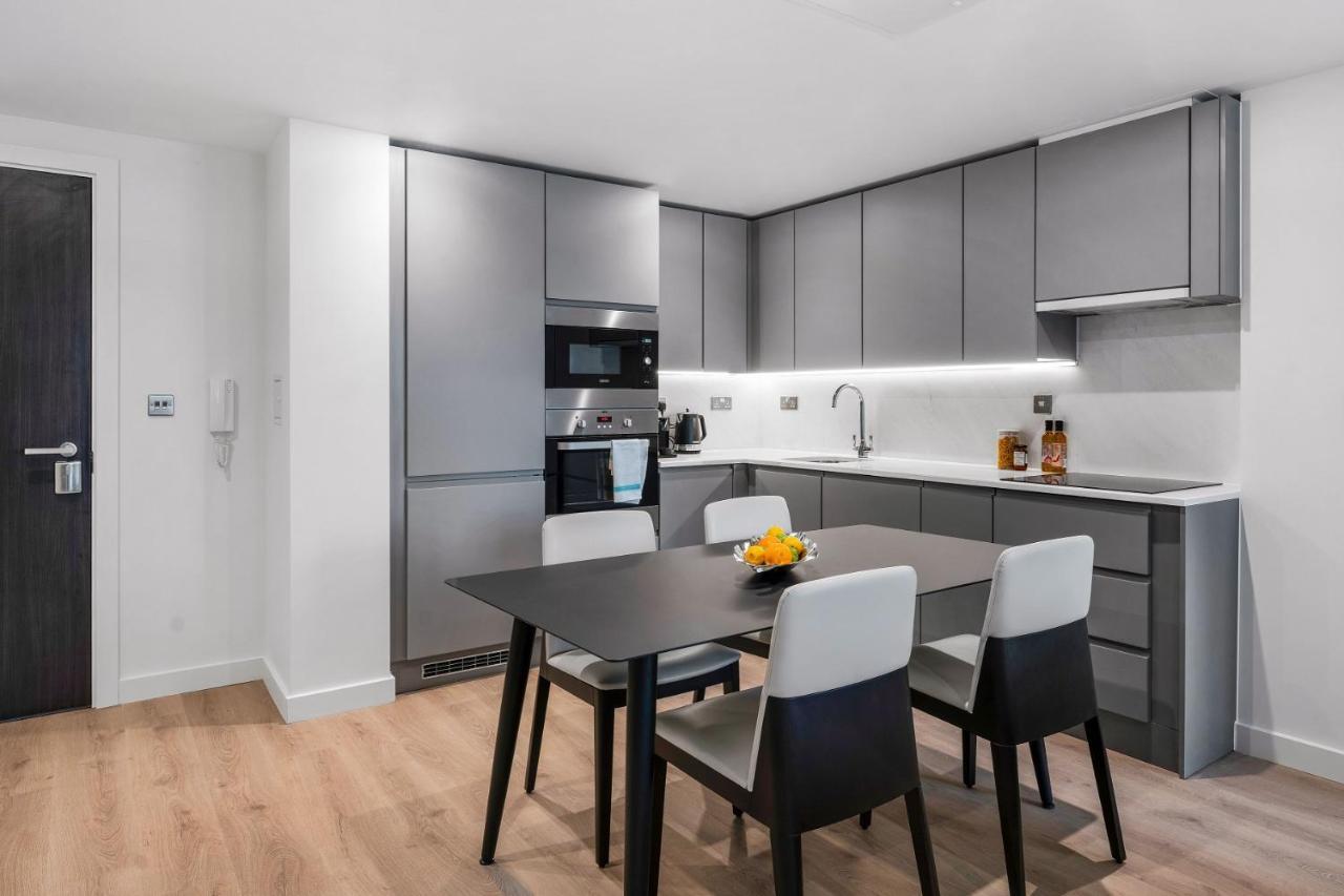 מנצ'סטר Citysuites 2 Aparthotel מראה חיצוני תמונה The photo shows a modern kitchen with a sleek and minimalist design. The cabinetry features a gray finish, and there are built-in appliances, including an oven and possibly a microwave. The countertop is light-colored, providing contrast to the darke