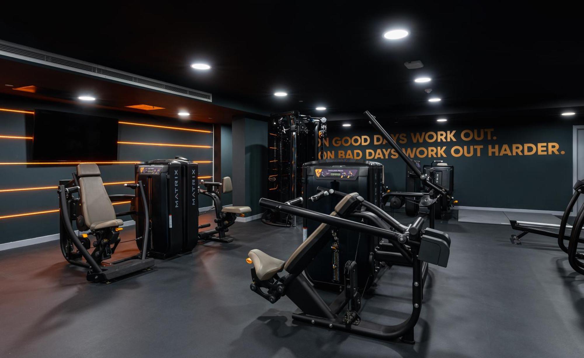 מנצ'סטר Citysuites 2 Aparthotel מראה חיצוני תמונה The photo shows a modern gym interior. The gym features various exercise machines, including weight training equipment. The flooring is dark, and the walls are adorned with motivational text that reads, "ON GOOD DAYS WORK OUT. ON BAD DAYS WORK OUT HA